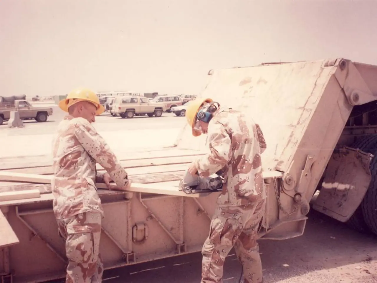 In the foreground of the picture I can see the truck on the road. I can see two men standing on the...