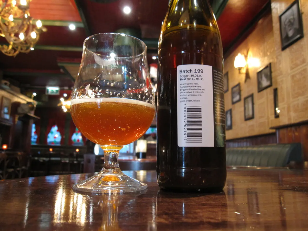 In this image there is a glass of wine and a wine bottle with a label on the table, and in the...