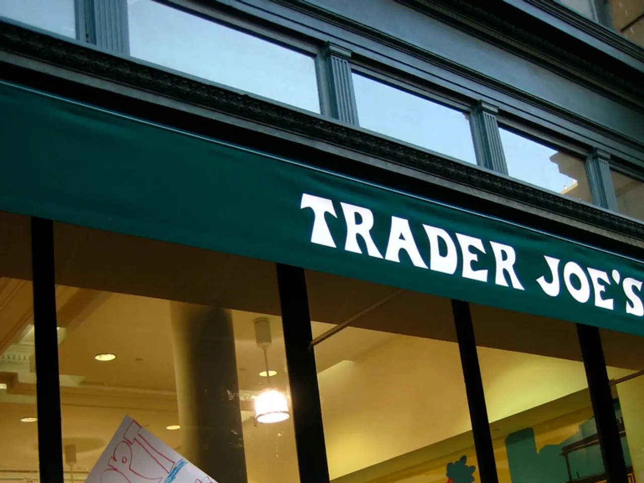 Here in this picture we can see a group of people standing near a store and protesting with banners...