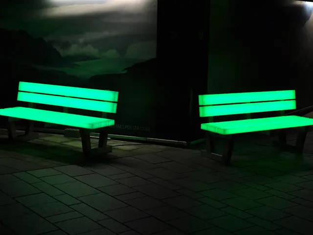 In this image we can see two benches. There are few posters on the walls. On poster we can see few...