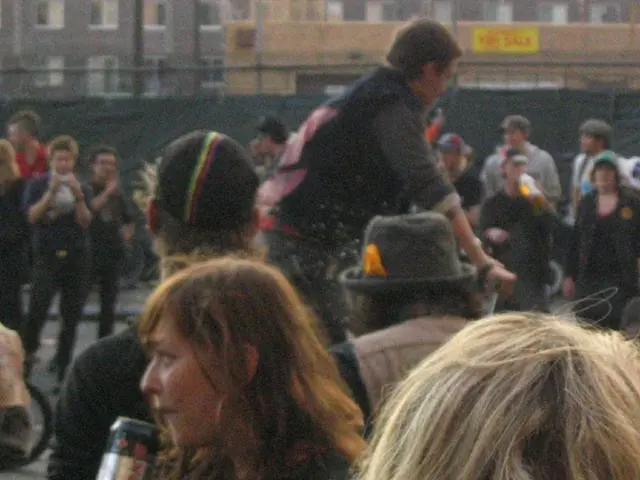 There is a crowd at the bottom of this image and we can see a fence with a black color curtain and...