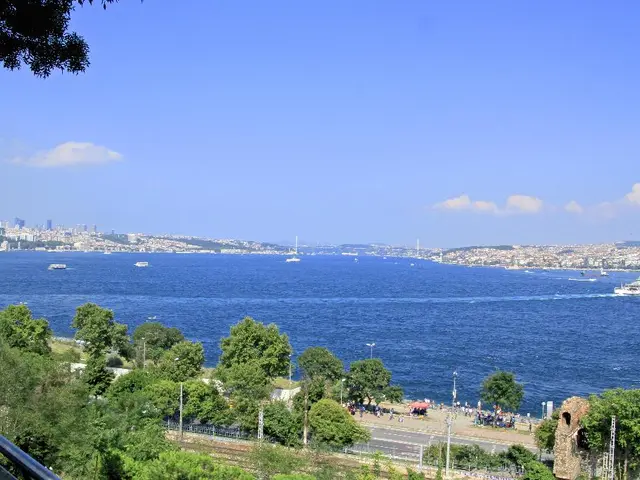 In the image there is a clear sky and below it there is a city. There are lot of buildings and...