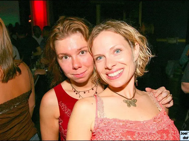 This picture describes about group of people, in the middle of the image we can see to women, they...