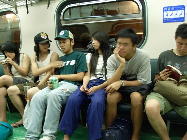 In this image we can see these people are sitting on the seats inside a metro train. In the...